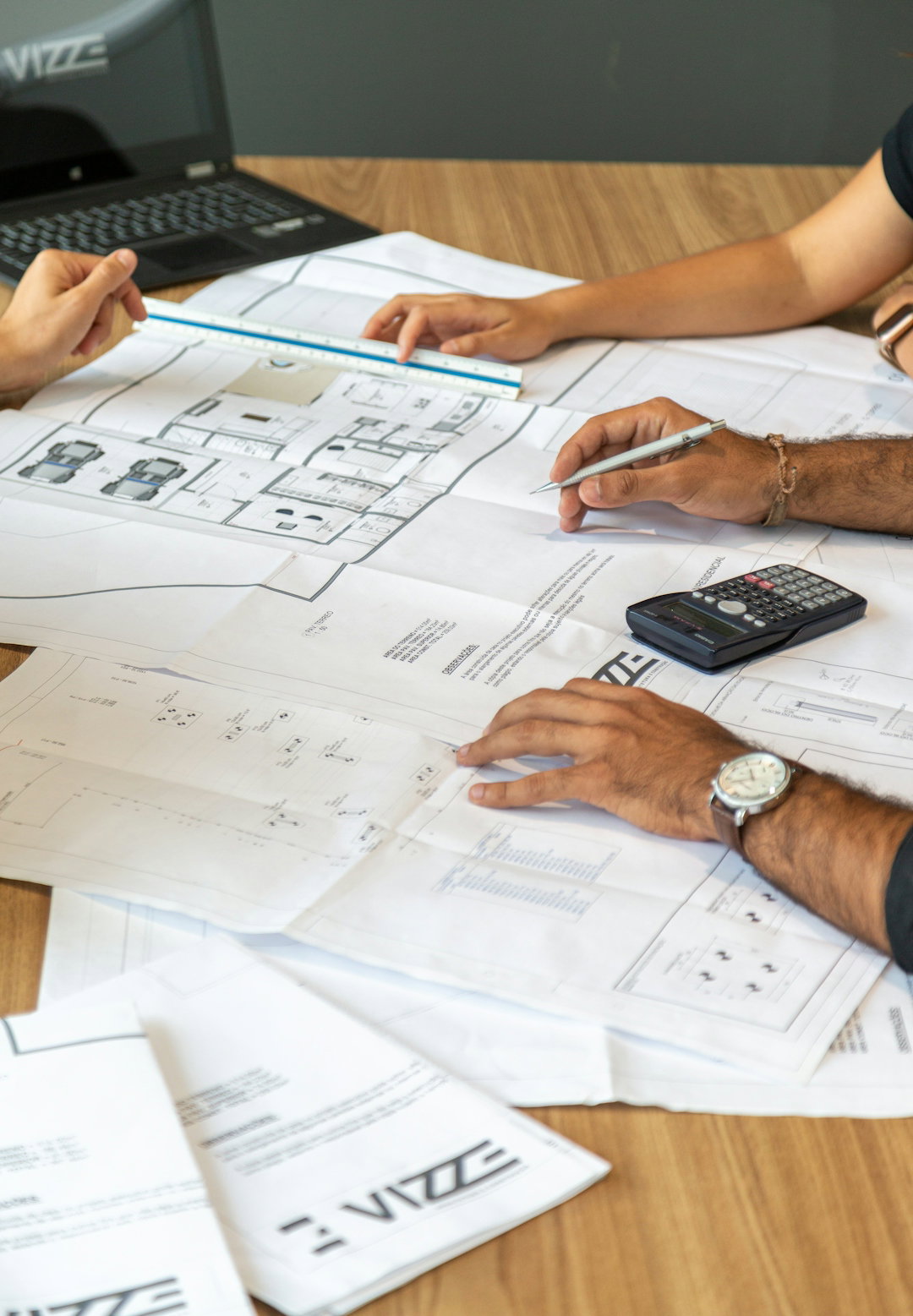 people-reviewing-architectural-blueprints-on-desk.jpg people reviewing architectural blueprints on desk